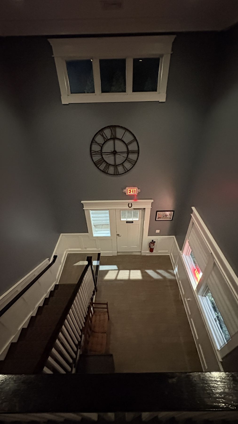The two-story entry foyer — private entrance below, clock on the wall