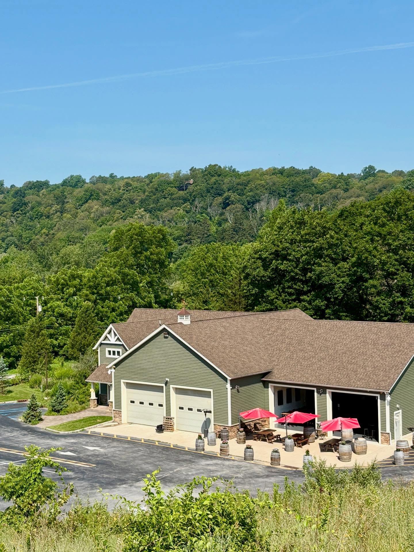 Vernon Brewing in high summer — red umbrellas out front, green hills behind