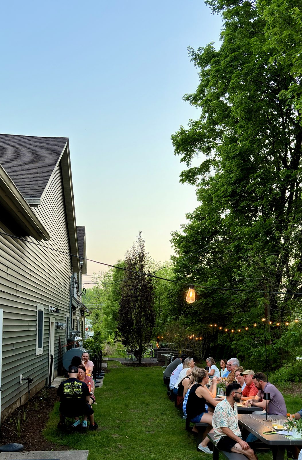 A summer evening gathering on the private lawn beside the house