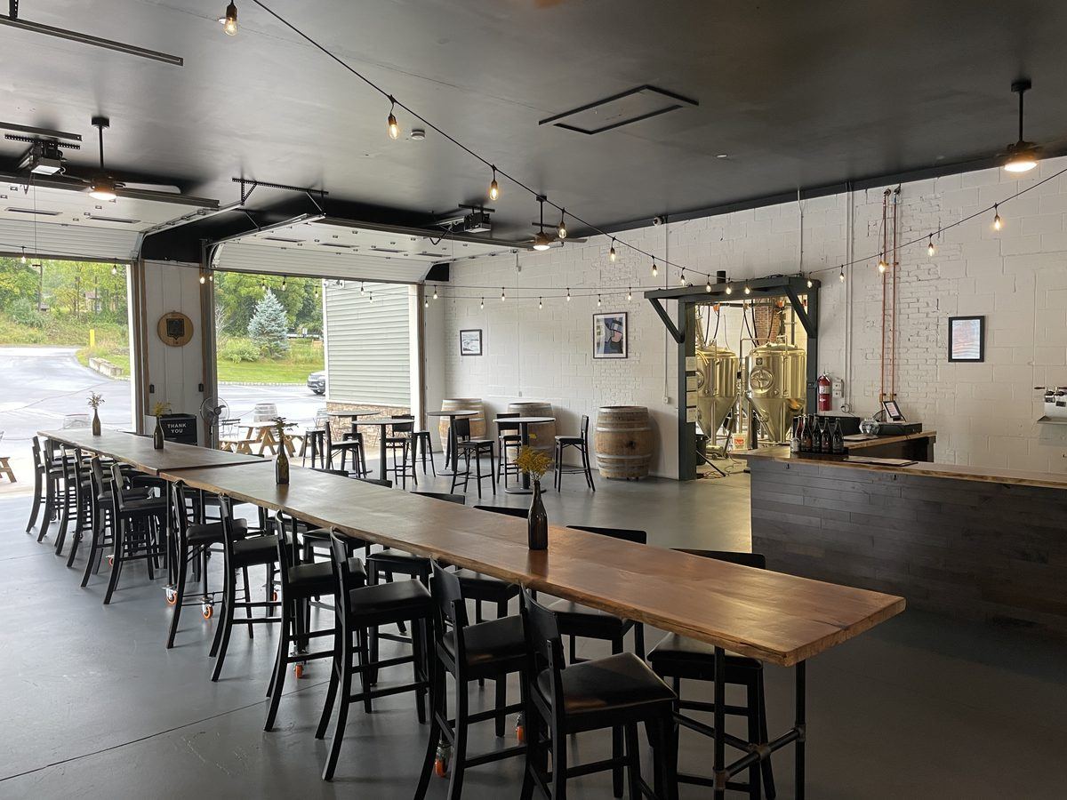 Brewing tanks visible from the taproom floor